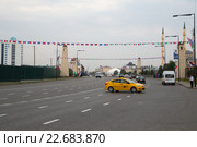 Желтая машина такси разворачивается на проспекте Ахмата Кадырова в городе Грозном, Чечня (2015 год). Редакционное фото, фотограф Ольга Шуклина / Фотобанк Лори