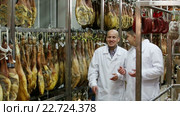 Technologist with butcher checking drying wurst and jamon at factory. Стоковое видео, видеограф Яков Филимонов / Фотобанк Лори