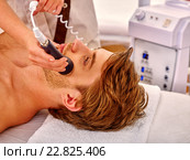 Young man receiving electric facial massage. Стоковое фото, фотограф Gennadiy Poznyakov / Фотобанк Лори