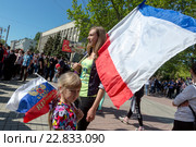 Женщина и девочка держат флаги России и Республики Крым во время парада в честь Дня Победы 9 мая в центре города Керчи, Республика Крым (2016 год). Редакционное фото, фотограф Николай Винокуров / Фотобанк Лори