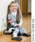 Little girl with socket extender and charging units indoors. Стоковое фото, фотограф Яков Филимонов / Фотобанк Лори