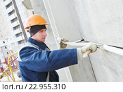 Facade plasterer sealing joint of building wall with putty mastic. Стоковое фото, фотограф Дмитрий Калиновский / Фотобанк Лори