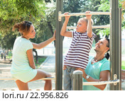 Family of three together training on pull-up bar. Стоковое фото, фотограф Яков Филимонов / Фотобанк Лори