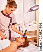Young man receiving electric facial massage. Стоковое фото, фотограф Gennadiy Poznyakov / Фотобанк Лори