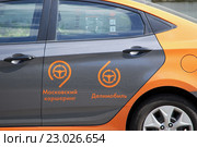 Каршеринг. Логотипы "Московского каршеринга" и сервиса поминутной аренды автомобиля "Делимобиль" на двери автомобиля (2016 год). Редакционное фото, фотограф Александр Замараев / Фотобанк Лори
