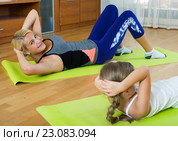 Positive mother and little daughter working out at home. Стоковое фото, фотограф Яков Филимонов / Фотобанк Лори