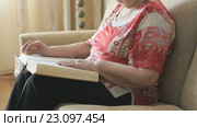 Старая женщина читает книгу. Стоковое видео, видеограф worker / Фотобанк Лори