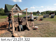 Двое мужчин опускают третьего в колодец (2016 год). Редакционное фото, фотограф Elizaveta Kharicheva / Фотобанк Лори