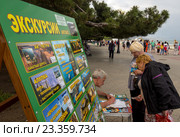 Туристы покупают билеты на экскурсию на набережной города Алушты, Крым (2016 год). Редакционное фото, фотограф Вячеслав Палес / Фотобанк Лори