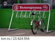 На велостоянке один не большой велосипед с красной рамой, хромированными крыльями у продуктового магазина (2016 год). Редакционное фото, фотограф Александр Кузнецов / Фотобанк Лори