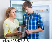 Frustraited starving female and man near fridge without any food. Стоковое фото, фотограф Яков Филимонов / Фотобанк Лори