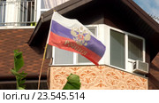 Российский флаг с гербом и надписью "Россия" развевается на фоне фасада дома (2016 год). Стоковое видео, видеограф Александр Замараев / Фотобанк Лори