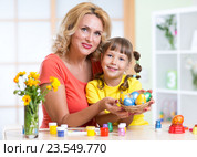 Mother and child girl showing painted Easter eggs at home interior. Стоковое фото, фотограф Оксана Кузьмина / Фотобанк Лори