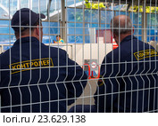 Два контролера сидят на скамейке за защитным периметром (2016 год). Редакционное фото, фотограф Вячеслав Палес / Фотобанк Лори