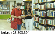Студенты встречаются в библиотеке, выбирают книги и общаются. Стоковое видео, видеограф Виктор Аллин / Фотобанк Лори