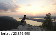 Мужчина приседает на вершине горы. Стоковое видео, видеограф Виктор Аллин / Фотобанк Лори