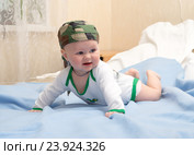 Малыш в камуфлированной бандане играет лежа на животе. Стоковое фото, фотограф Андрей Некрасов / Фотобанк Лори