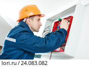 electrician with screwdriver repair switching electric actuator in fuse box. Стоковое фото, фотограф Дмитрий Калиновский / Фотобанк Лори