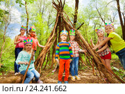 Happy kids building Injun's wigwam in the forest. Стоковое фото, фотограф Сергей Новиков / Фотобанк Лори