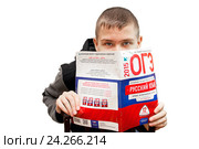 Подросток держит в руках сборник типовых экзаменационных вариантов по русскому языку. 9 класс. Сдаем экзамены (2015 год). Редакционное фото, фотограф Наталья Осипова / Фотобанк Лори