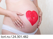 Беременная женщина с нарисованным губной помадой сердцем на животе. Стоковое фото, фотограф Андрей Некрасов / Фотобанк Лори