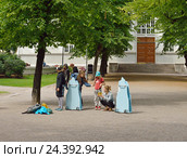 Молодые люди и дети ловят покемонов (игра Pokemon GO) в парке. Хельсинки, Финляндия (2016 год). Редакционное фото, фотограф Валерия Попова / Фотобанк Лори