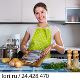 housewife trying new recipe of sprattus in kitchen. Стоковое фото, фотограф Яков Филимонов / Фотобанк Лори