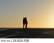 Молодые люди, мужчина и женщина (силуэты), наблюдают за закатом солнца на острове Uunisaari, Хельсинки, Финляндия (2016 год). Стоковое фото, фотограф Валерия Попова / Фотобанк Лори