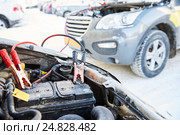 Charging automobile discharged battery by booster jumper cables at winter. Стоковое фото, фотограф Дмитрий Калиновский / Фотобанк Лори