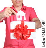 Parts of hands with house and white gift with red bow isolated on white background. Стоковое фото, фотограф Дубровская Татьяна / Фотобанк Лори