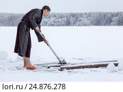 Мужчина в халате рубит лопатой примерзший лед в проруби для купания. Стоковое фото, фотограф Кекяляйнен Андрей / Фотобанк Лори