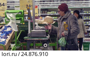 Люди в супермаркете взвешивают на весах продукты (2017 год). Редакционное видео, видеограф Юлия Зайцева / Фотобанк Лори