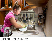 The girl washes the bowl in the sink. Девушка моет тарелку в раковине. Стоковое фото, фотограф Климов Денис / Фотобанк Лори