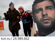Александр Гудков (слева) и Дмитрий Хрусталев (справа) с портретом Ивана Урганта принимают участие в Новаторских гонках на санях в городе Москве, Россия (2017 год). Редакционное фото, фотограф Николай Винокуров / Фотобанк Лори