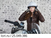 Woman motorcyclist wearing a white open helmet on her head before the bike trip. Стоковое фото, фотограф Кекяляйнен Андрей / Фотобанк Лори