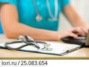 Close-up of stethoscope and paper on background of doctor hands with pc. Стоковое фото, фотограф Оксана Кузьмина / Фотобанк Лори
