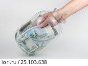 Рука достает из стеклянной трехлитровой банки тысячу российских рублей. Стоковое фото, фотограф Иванов Алексей / Фотобанк Лори