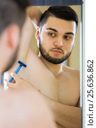 Handsome man shaving his armpit. Стоковое фото, фотограф Яков Филимонов / Фотобанк Лори