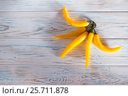 Yellow chili pepper on a wooden light background. View from above. Free space for inscriptions on the left. Стоковое фото, фотограф Татьяна Дубчук / Фотобанк Лори