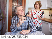 Супруга недовольная бездельем мужа, мужчина переключает каналы телевизионным пультом. Стоковое фото, фотограф Кекяляйнен Андрей / Фотобанк Лори