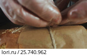Hands Ties a Wrapper for Sandwich Wrapper. Стоковое видео, видеограф Станислав Панкратов / Фотобанк Лори