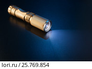 Working flashlight on a blue surface. Стоковое фото, фотограф Alexander / Фотобанк Лори