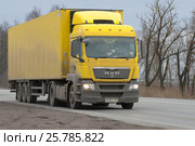 Желтый грузовой MAN TGS 2008 модельного года c полуприцепом на шоссе сумрачным мартовским днем (2017 год). Редакционное фото, фотограф Виктор Карасев / Фотобанк Лори