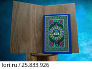 Священная книга мусульман - Коран лежит на подставке в мечети во время намаза (2017 год). Редакционное фото, фотограф Николай Винокуров / Фотобанк Лори