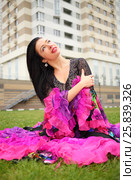 Young woman in beautiful skirt zingara poses on lawn near building. Стоковое фото, фотограф Losevsky Pavel / Фотобанк Лори