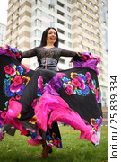 Young woman in beautiful skirt zingara dances on lawn near building. Стоковое фото, фотограф Losevsky Pavel / Фотобанк Лори