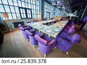 RUSSIA, MOSCOW - DEC 28, 2014: Restaurant hall, served tables with plate Reserved and soft armchairs in the restaurant Siren (Lilac), located in Sokolniki park at Pesochnaya alley. Редакционное фото, фотограф Losevsky Pavel / Фотобанк Лори