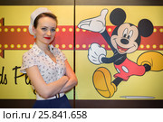 RUSSIAN, MOSCOW - JAN 18, 2015: Beautiful young woman near wall with art Mickey Mouse in Beverly Hills Diner restaurant. Редакционное фото, фотограф Losevsky Pavel / Фотобанк Лори