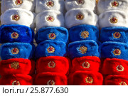 Военные шапки с советскими кокардами выложены в цвета российского триколора на сувенирном прилавке в городе Москве, Россия. Стоковое фото, фотограф Николай Винокуров / Фотобанк Лори