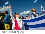 Люди стоят с флагами Греции на черноморской набережной во время открытия Первого всероссийского молодёжного фестиваля греческой культуры «Крымский маяк» в городе Ялте, Республика Крым (2016 год). Редакционное фото, фотограф Николай Винокуров / Фотобанк Лори